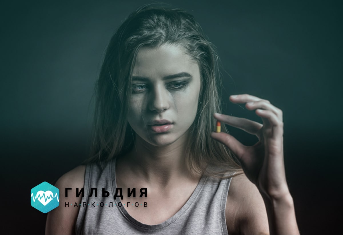 Девушка смотрит на таблетку